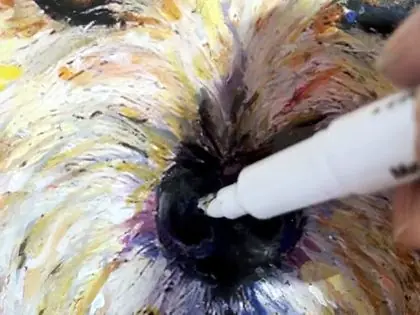 White paint pen adding a highlight to a dog’s nose.